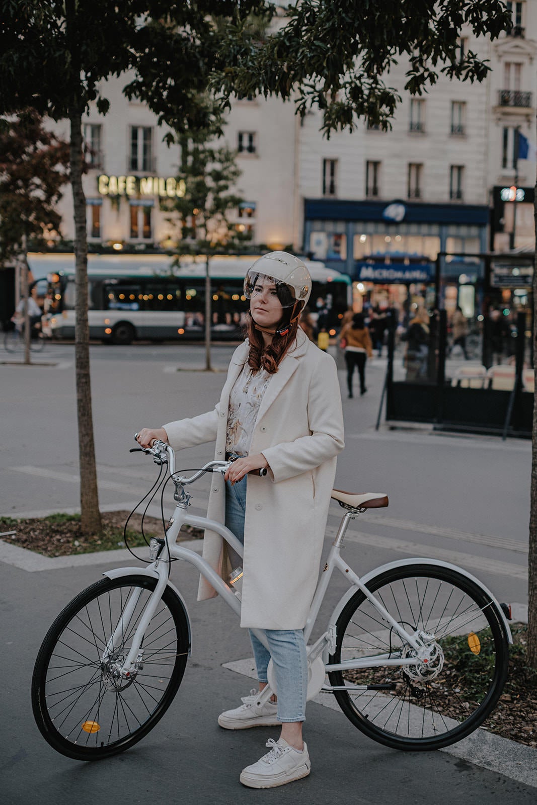 Casque Vélo Urbain Mârkö Helmet Tandem Blanc Ivory porté par une femme sur un vélo